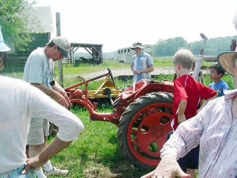 John showing us one of his small tractors to which the tools are attached in front instead of in the rear. John showing us one of his small tractors to which the tools are attached in front instead of in the rear.